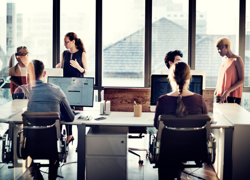 Employees sitting and standing around office space