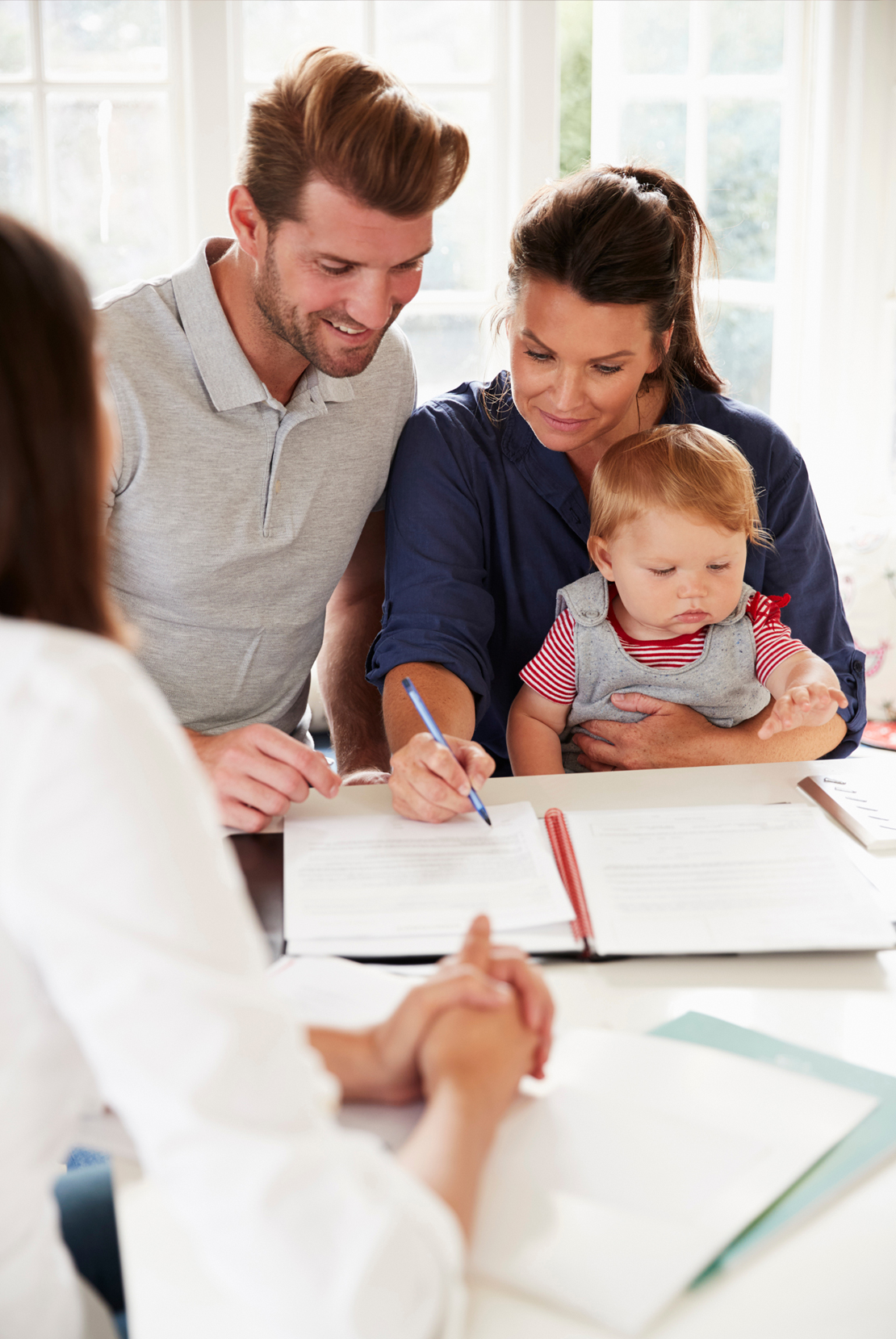 Couple with child taking to mortgage advisor at table